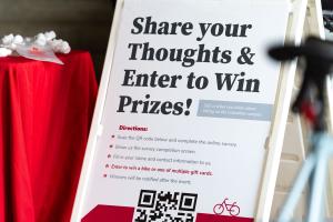 A sign that reads "share your thoughts & enter to win prizes!"