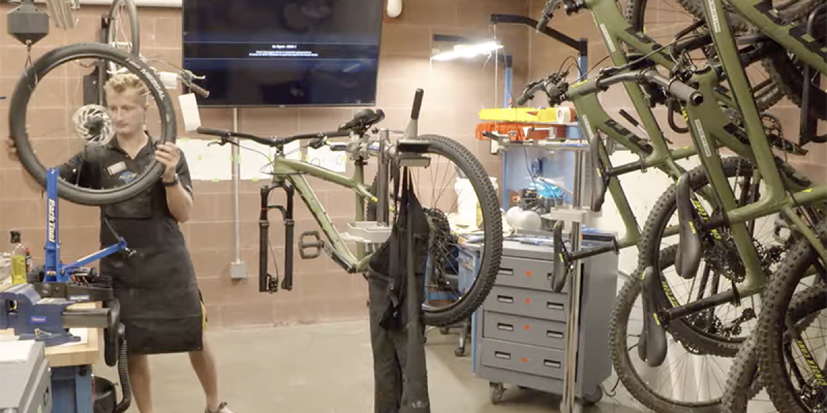 student fixing bicycle in the bicycle shop