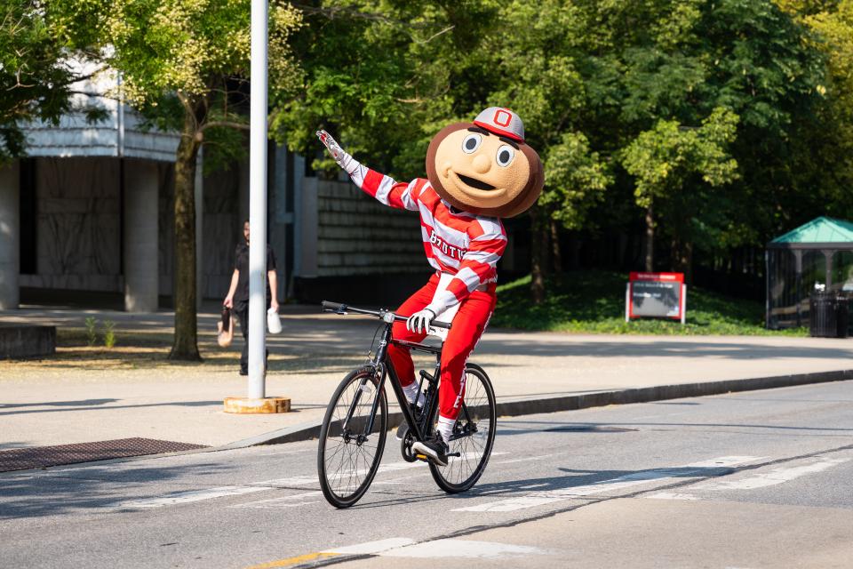 Brutus Buckeye riding a bicycle